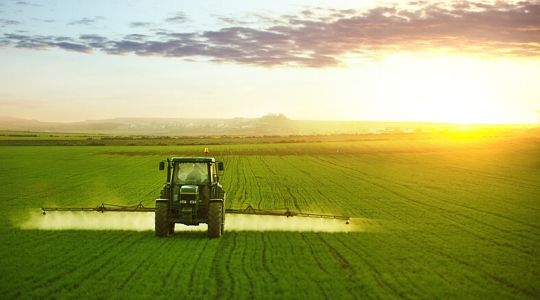 Un agriculteur épand des engrais sur son champ